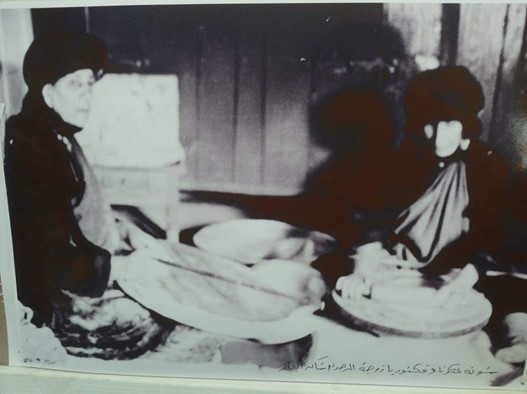 Black and white photo of two women baking traditional wedding bread, Karamles, Nineveh, Iraq. Credit. Qusay Maslob